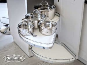 Corner cabinet with an appliance garage featuring pull-out shelves holding stainless steel pots and pans