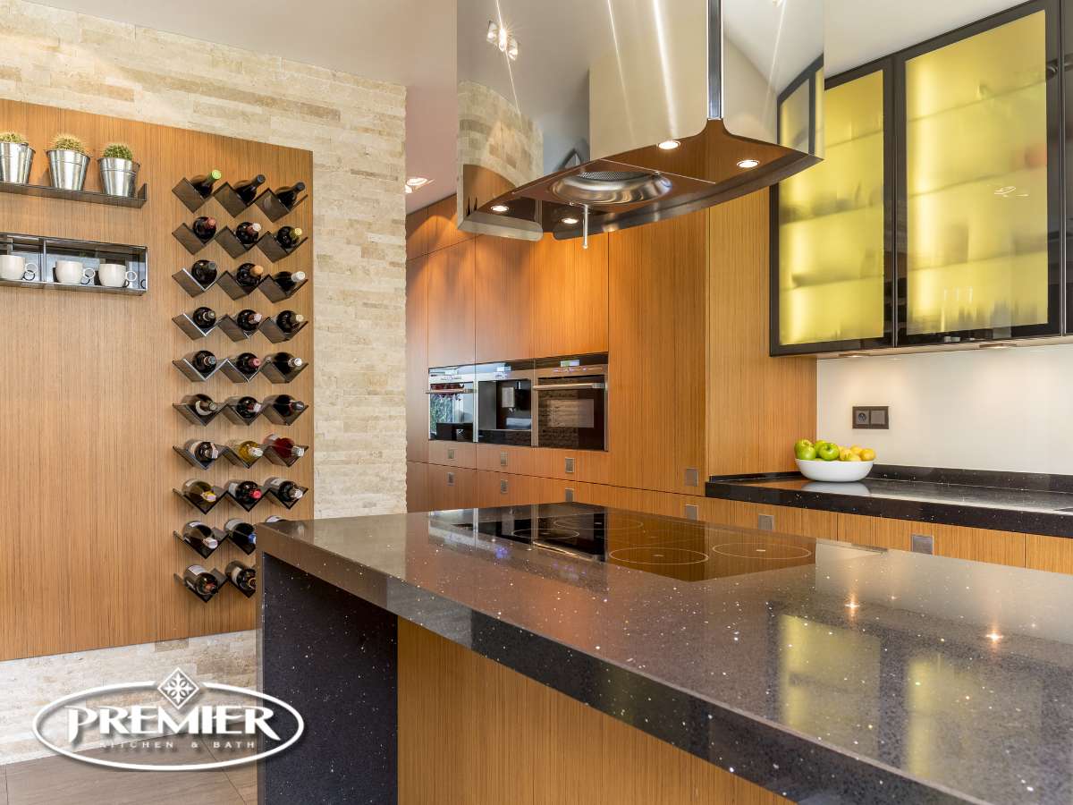 Modern kitchen with a sleek design featuring a built-in wine rack, glossy countertops, and a Premier Kitchen & Bath logo in the corner