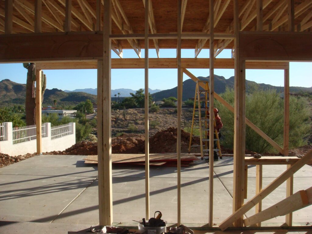 Can I add a room to my house? Photo taken through exterior wall framing at a house under construction.